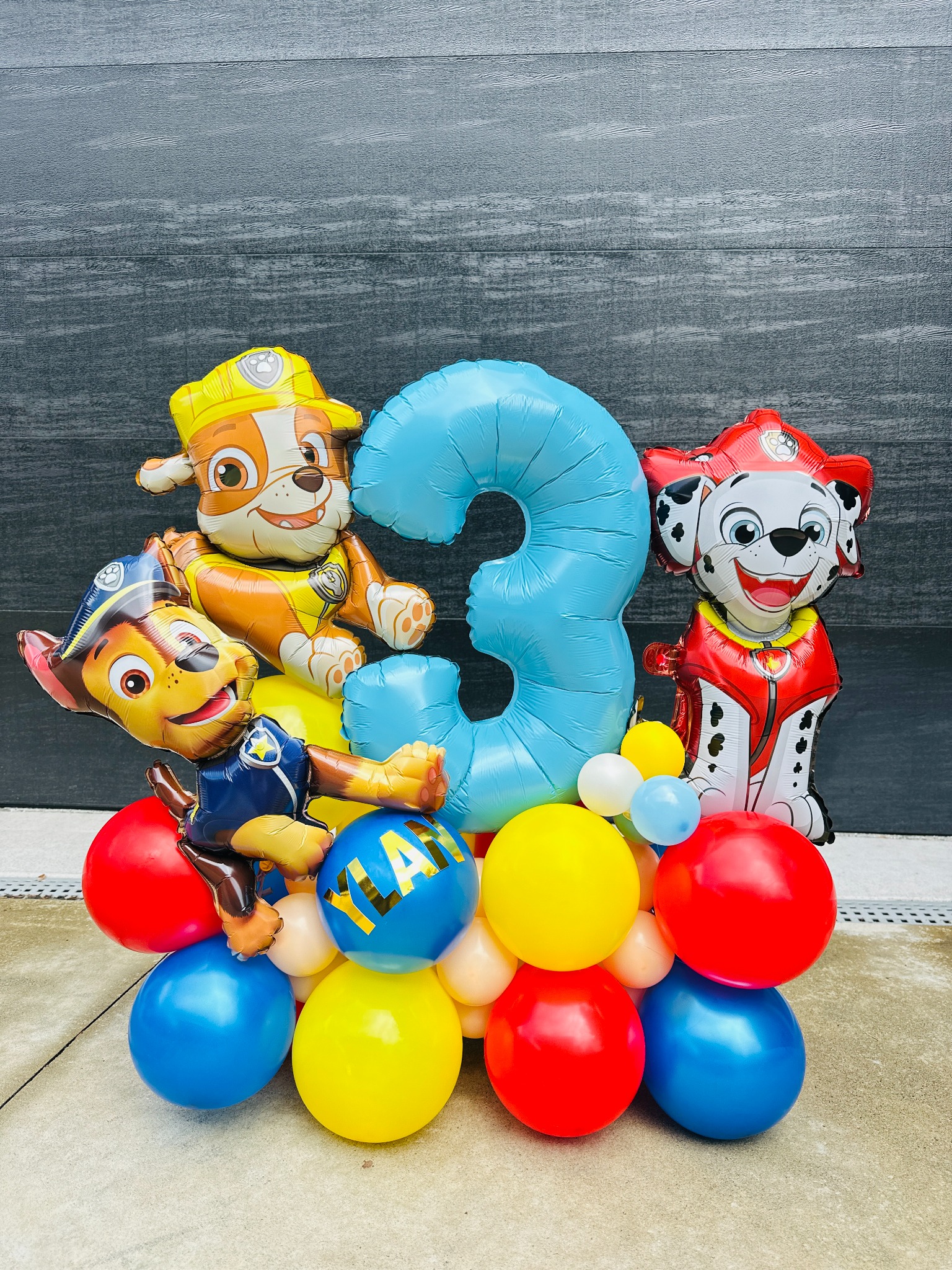 Character balloon stack for a third birthday